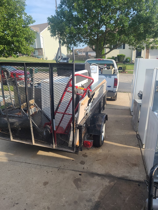 A junk removal pickup of old appliances by GJR Scrap Metals in a residential driveway in Kansas City, MO.