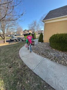 A Junk It OR Dump It service provider in Independence, MO, carrying bags and boxes from a residential property.