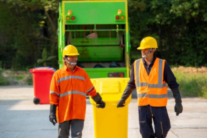 Junk removal team with bins and a garbage truck, ready for service from JUNK Monster in Santa Ana, CA.