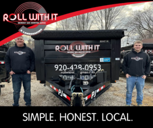 Two Roll With It team members standing proudly with their junk removal dumpster trailer in Appleton, WI.