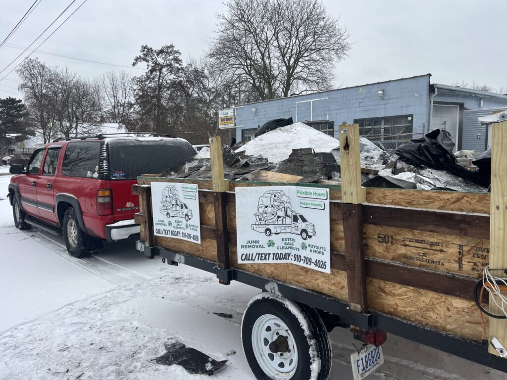 A red truck pulling a trailer loaded with debris and junk, showcasing a completed job by Feelin Good Junk Removal & Estate Sales at 1111 Debra Lane.