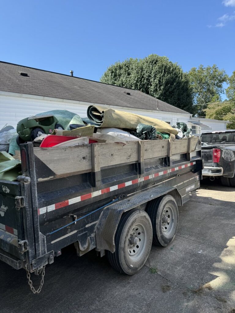 A utility trailer fully loaded with various items and debris, ready for transport by Trash Monkey Junk Removal in Charleston, WV.