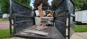 A dump trailer loaded with a hot tub, metal, wood, and other debris for junk removal in Sioux Falls, SD.