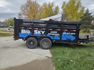 A Big Sky Junk Removal LLC trailer partially loaded with large items for removal in Billings, MT.