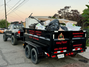 A Wasted Junk Removal truck and trailer fully loaded with household waste and debris after a job in Corona, CA.