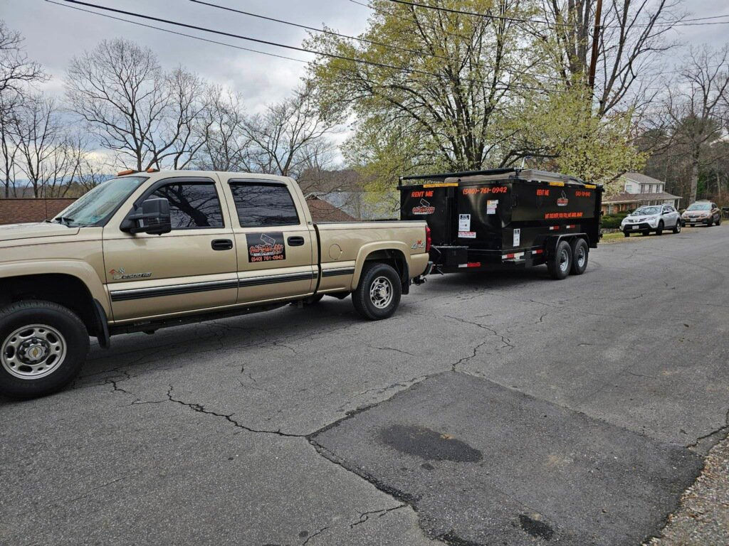 A Haul Rollers LLC truck and dump trailer parked on a residential street, ready for junk removal service in Roanoke, VA.