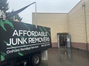 An OnPoint Removal Services truck, branded 'Affordable Junk Removers', backed up to a building entrance for a job in Vancouver, WA.