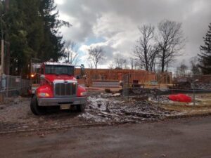A Champion Waste Removal, Inc. truck and dumpster at a construction site for debris removal in Orange, NJ.