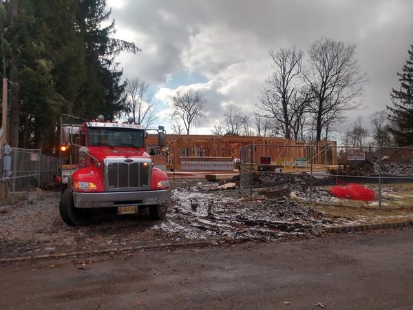 A Champion Waste Removal, Inc. truck and dumpster at a construction site for debris removal in Orange, NJ.
