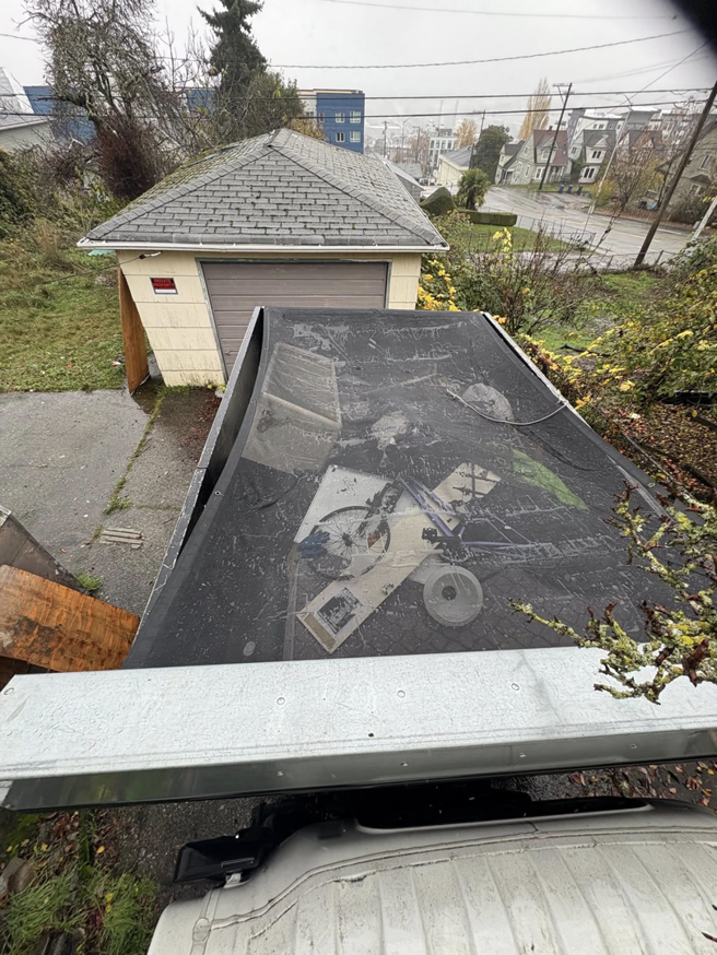 Overhead view of an All City Junk Removal truck, loaded with items and covered with a tarp, after a junk removal job in Kent, WA.