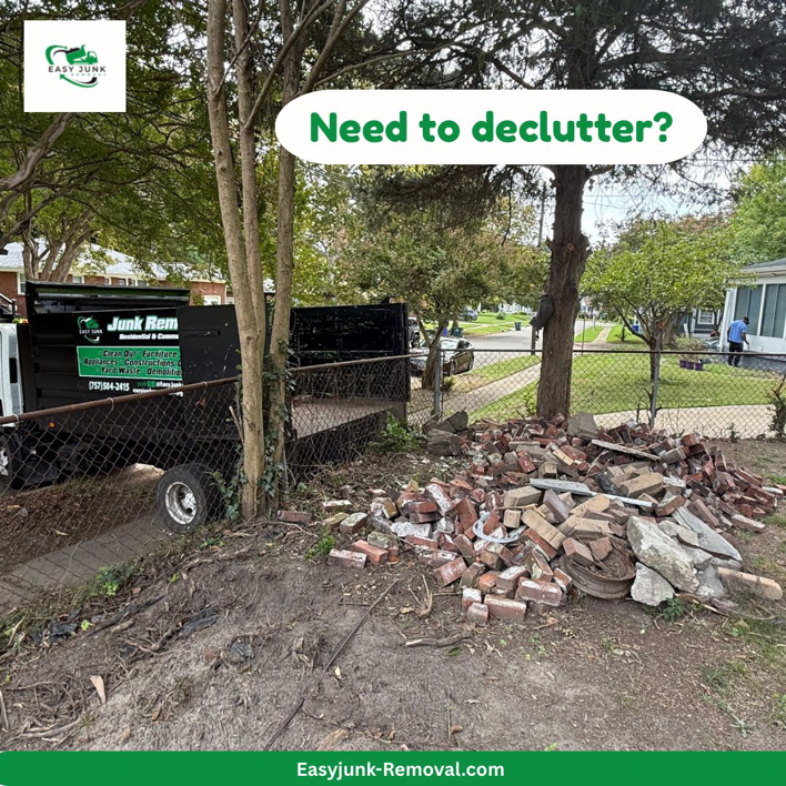 A junk removal truck parked next to a large pile of bricks and concrete debris for pickup by Easy junk removal in Newport News, VA.