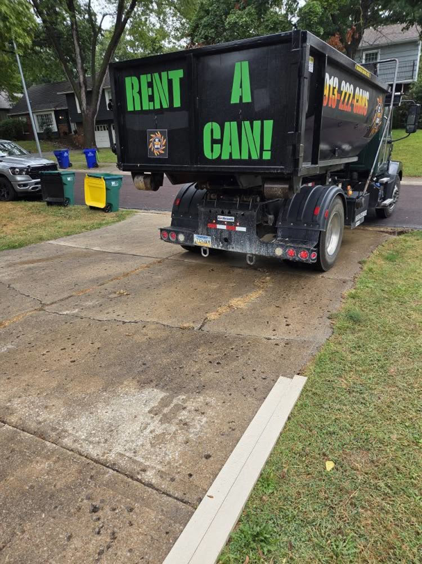 A KC TRASH GUYS LLC truck with a "RENT A CAN!" dumpster on a residential driveway in Johnson county, MO.