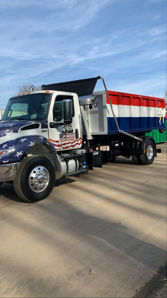 A Bragg About This Dump junk removal truck with a roll-off dumpster ready for service in Columbus, OH.