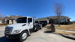 A 402 Container truck with a dumpster on a residential driveway for junk removal in Omaha, NE.