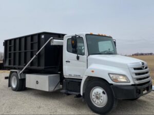 A 402 Container truck with an empty dumpster, ready for junk removal services in Omaha, NE.