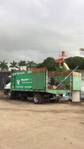 A junk removal truck filled with green waste and debris after a successful cleanout by Gator Junk Removal in Miami, FL.