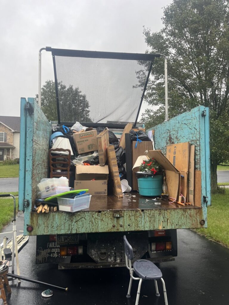 The back of a junk removal truck filled with various household items and boxes after a pickup by You Call We Haul Junk Removal in Milwaukee, WI.