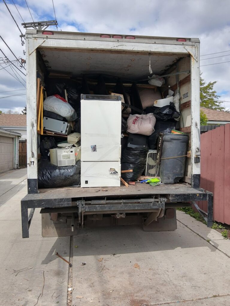 A junk removal truck filled with various debris and appliances after a job by In & Out Junk Removal Service LLC in Chicago, IL.