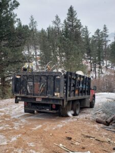 A red junk removal truck loaded with metal items and debris by Bear Foot Junk Removal in Bailey, CO.