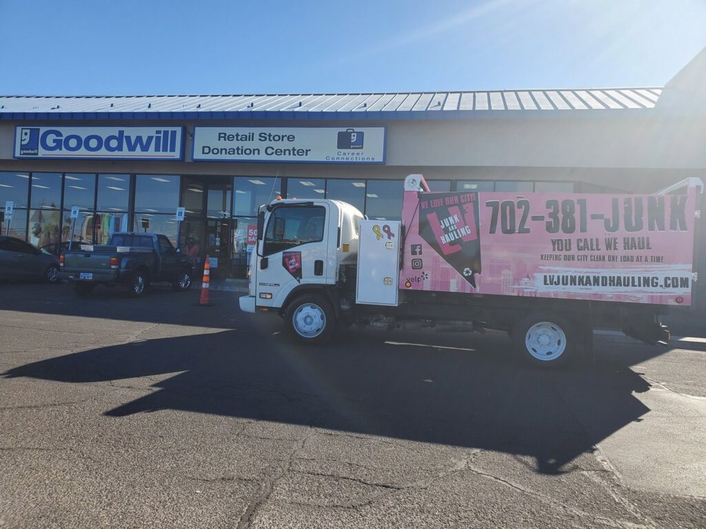 A branded junk removal truck from Las Vegas Hauling Junk & Moving parked outside a Goodwill Donation Center in Las Vegas, NV