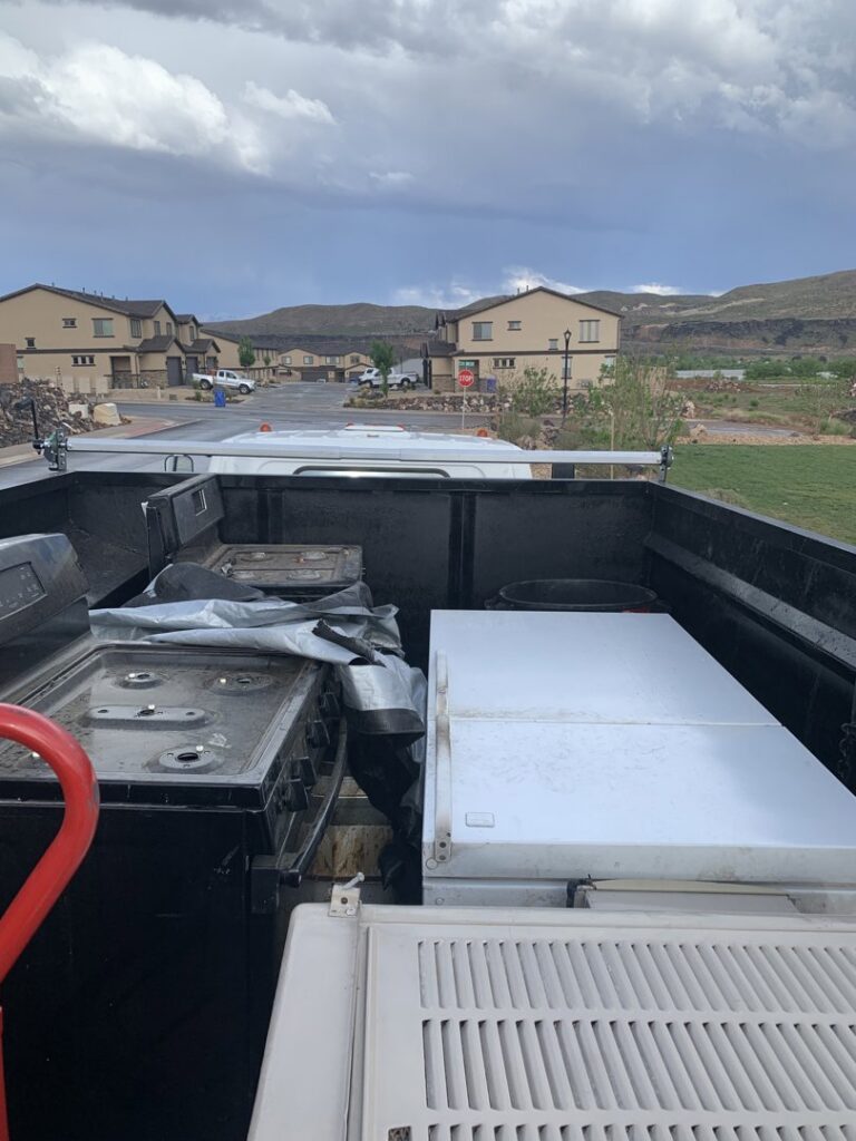 A junk removal truck loaded with old appliances and other items by YEE-HAul Trash Removal in St. George, UT.