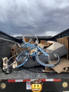 A junk removal truck loaded with a bicycle, mattress, and cardboard boxes by YEE-HAul Trash Removal in St. George, UT.