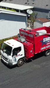 An overhead view of a Stars Junk Removal truck fully loaded with various items of junk in San Jose, CA.