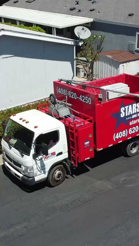An overhead view of a Stars Junk Removal truck fully loaded with various items of junk in San Jose, CA.