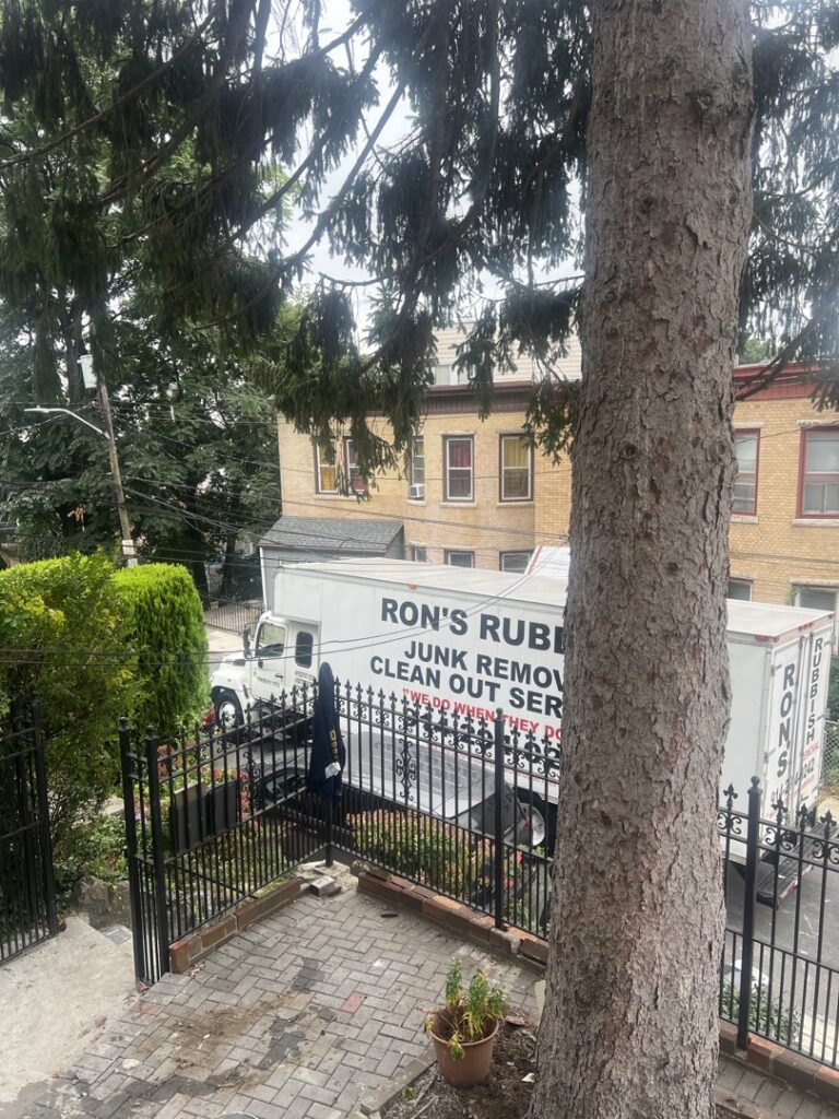A Ron's Rubbish & Junk Removal Cleanout Services truck parked on a residential street in Yonkers, NY, seen from above.