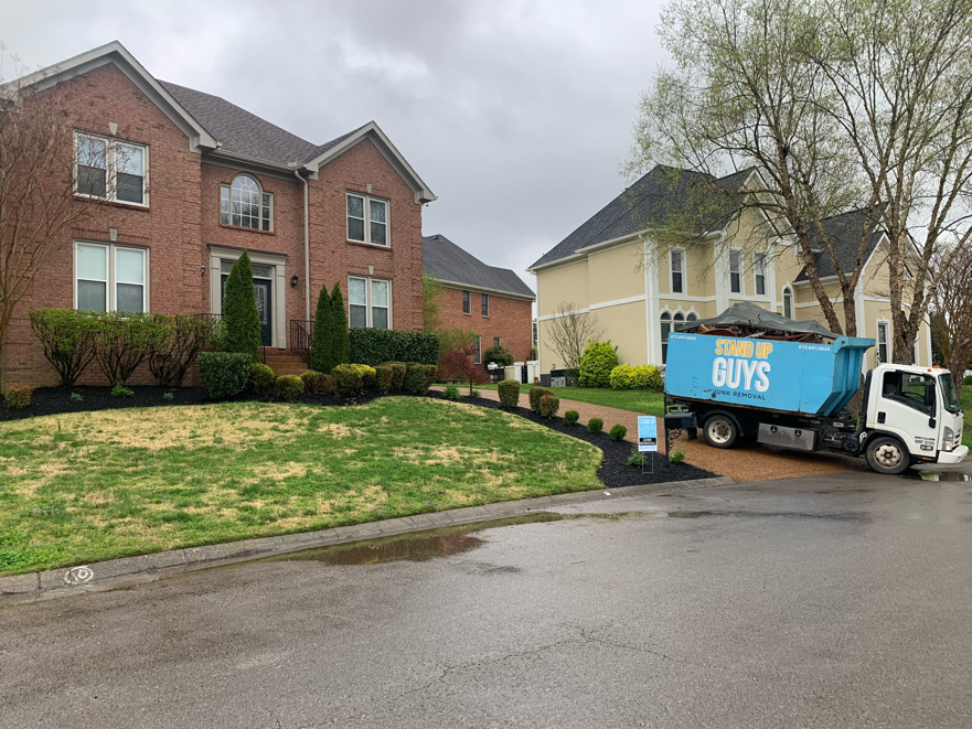 A Stand Up Guys Junk Removal truck parked in front of a residential home in Nashville, TN, ready for service.