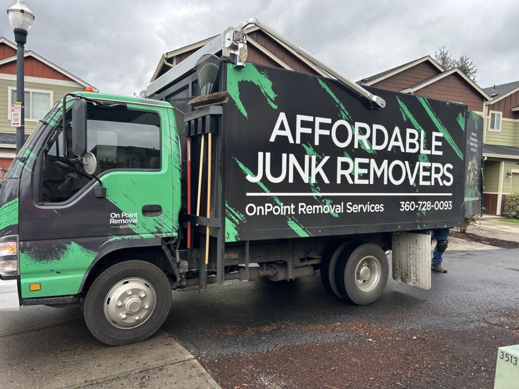 A branded OnPoint Removal Services truck, 'Affordable Junk Removers', parked on a residential street in Vancouver, WA.