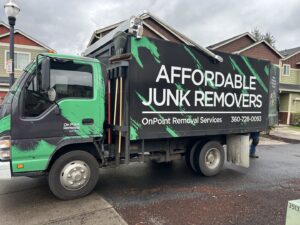 A branded OnPoint Removal Services truck, 'Affordable Junk Removers', parked on a residential street in Vancouver, WA.