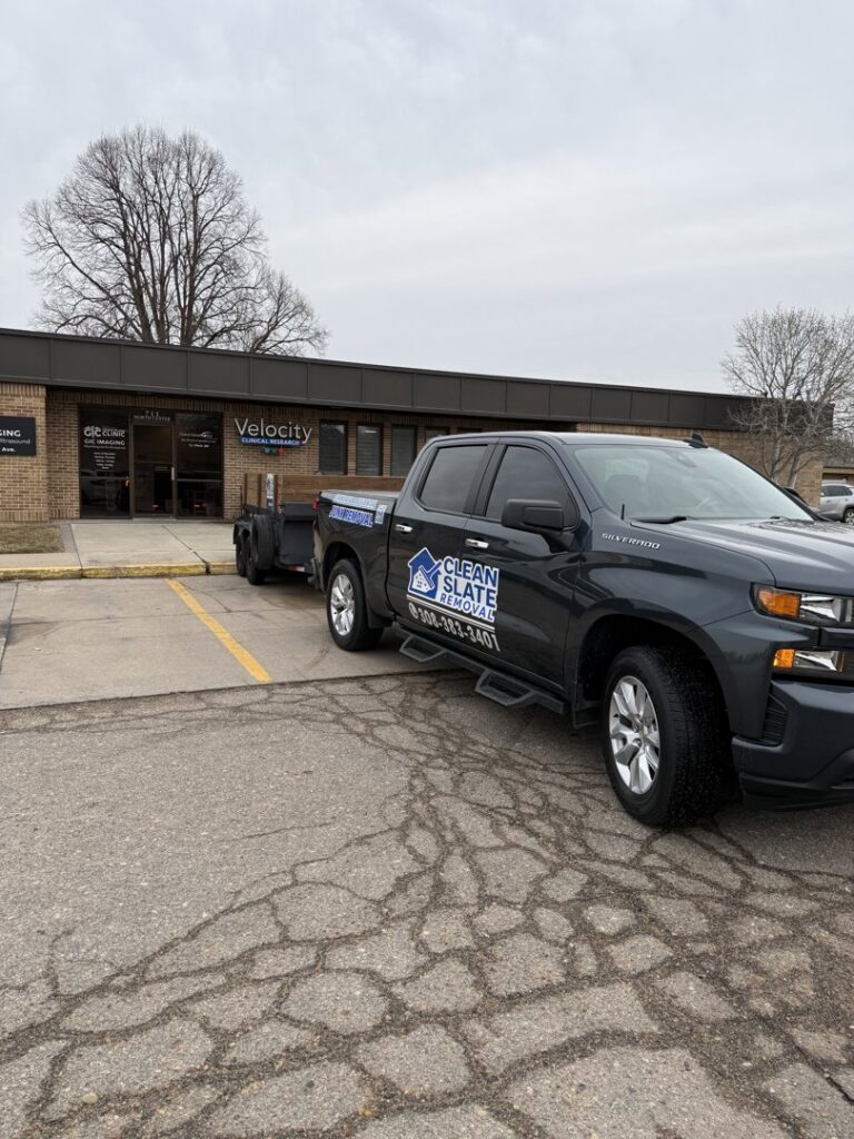 Clean Slate Removal truck and trailer loaded with junk parked at a commercial property in Grand Island, NE.