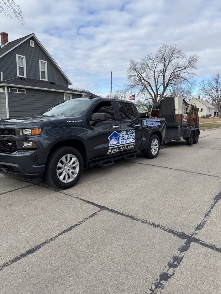 A Clean Slate Removal truck pulling a trailer loaded with various items for junk removal in Grand Island, NE.
