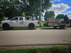 A junk removal truck and trailer from The Junkyard Gentlemen LLC loaded with various items in Appleton, WI.
