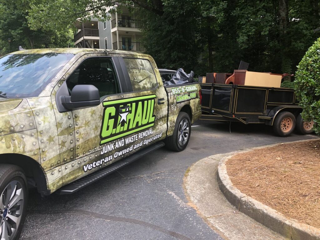 A G.I.HAUL ATLANTA truck pulling a trailer loaded with furniture for junk removal in Atlanta, GA.