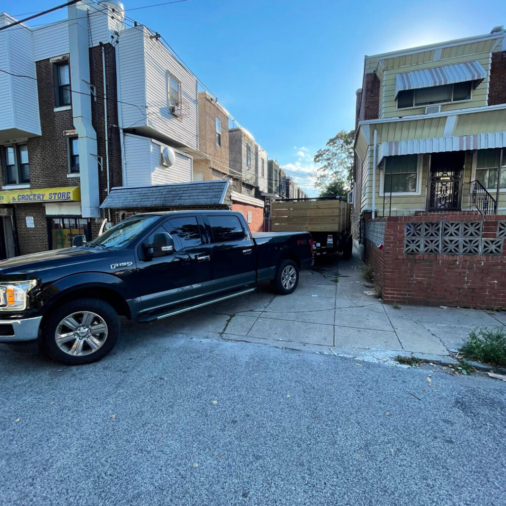 A junk removal truck and dump trailer parked on a street, ready for or after a job by JPC Junk Removal & Demolition in Philadelphia, PA.