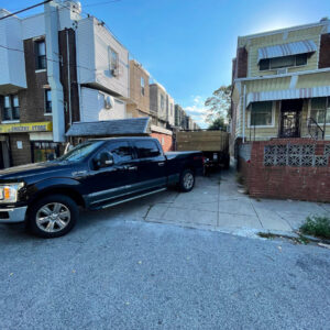A junk removal truck and dump trailer parked on a street, ready for or after a job by JPC Junk Removal & Demolition in Philadelphia, PA.