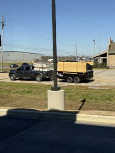 A pickup truck towing a large trailer, ready for junk and debris hauling by Pop & Son's Junk Removal in Montevallo, AL.