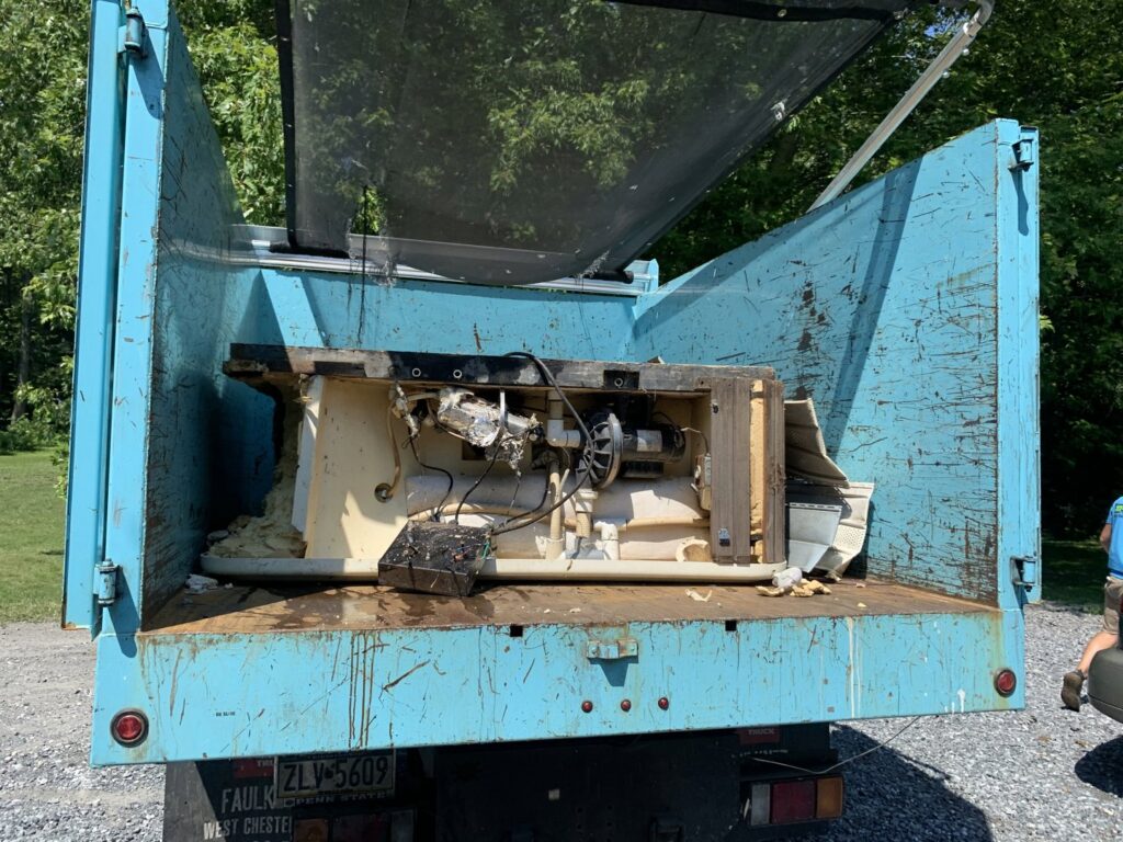 A junk removal truck loaded with a disassembled hot tub or large appliance by You Call We Haul Junk Removal in Milwaukee, WI.