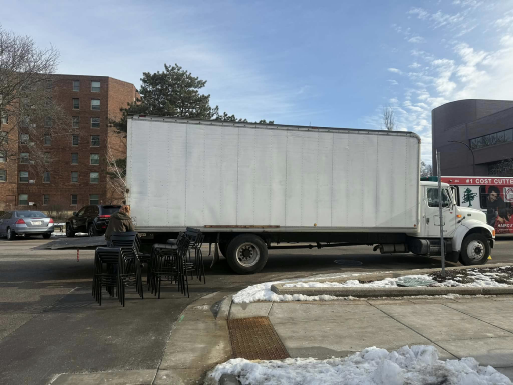 A Fish Junk Removal And Trash Out Services LLC truck parked next to a pile of black stools for removal in Janesville, WI.