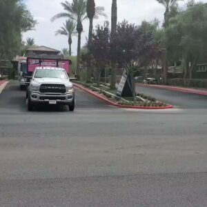 Branded junk removal trucks from Las Vegas Hauling Junk & Moving driving on a street in Las Vegas, NV