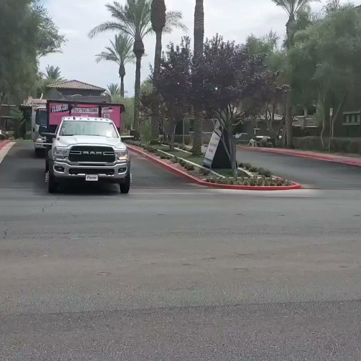Branded junk removal trucks from Las Vegas Hauling Junk & Moving driving on a street in Las Vegas, NV