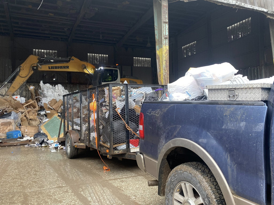 A Harris Family Hauling & Snow Removal LLC truck and loaded trailer at a junk disposal facility in Independence, MO.