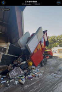 A Jack Spades Junk Removal trailer unloading mattresses and various debris at a disposal site in St. Petersburg, FL.