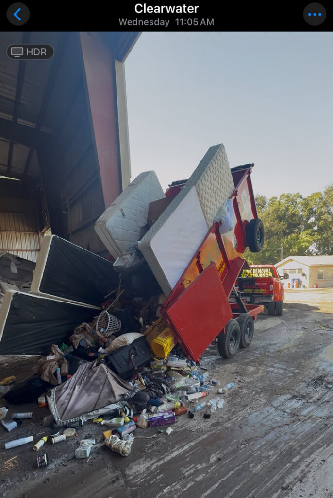 A Jack Spades Junk Removal trailer unloading mattresses and various debris at a disposal site in St. Petersburg, FL.