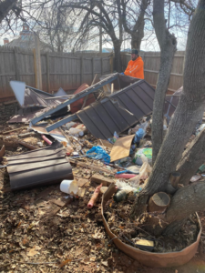 A Junk Warriors team member removing shed debris and yard waste from a backyard in Oklahoma City, OK.