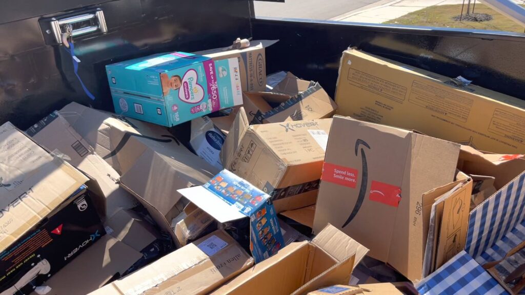 A JunkStart truck filled to the brim with cardboard boxes and various household items for removal in San Antonio, TX.