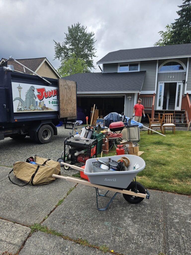 A Junkzilla Inc. crew removing a large collection of household junk and debris from a driveway in Everett, WA.