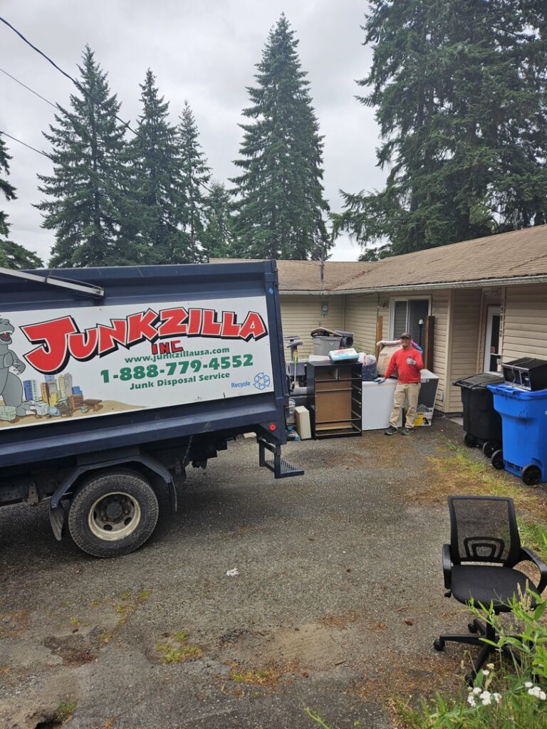 A Junkzilla Inc. truck parked at a residential property with a pile of junk awaiting removal in Everett, WA.